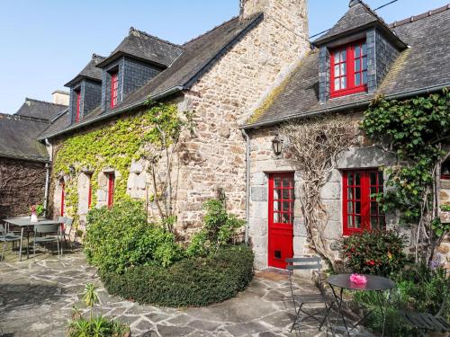 ein altes Steinhaus mit roten Türen und einer Terrasse in der Unterkunft Holiday Home Dolce Vita by Interhome in Plouha