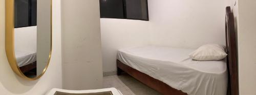 a small room with a bed and a mirror at Departamento 4 habitaciones 12 personas vista al mar 8vo piso Playa Almendro in Tonsupa