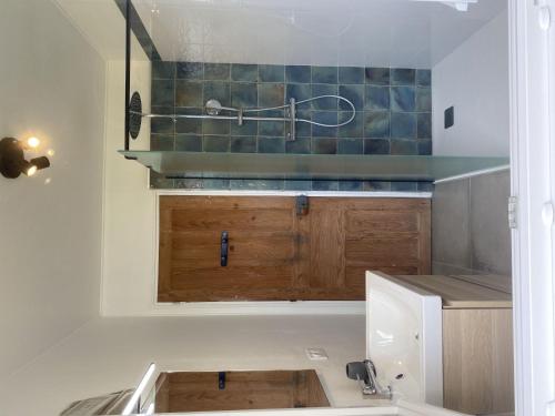 une cuisine avec des armoires en bois et un évier dans l'établissement Holiday Home Les Cordylines by Interhome, à Anneville-sur-Mer