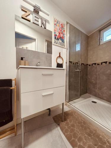 La salle de bains est pourvue d'une commode blanche et d'une douche. dans l'établissement Cosy lodge, à Loyettes