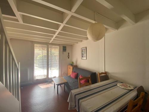une chambre avec un lit, une table et des chaises dans l'établissement Villa patio proche du port, à Capbreton