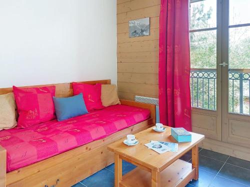 un salon avec un canapé rouge et une table dans l'établissement Apartment Les erables by Interhome, à Saint-Gervais-les-Bains