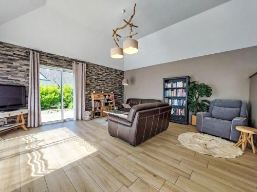 a living room with a couch and a tv at Holiday Home Orphée by Interhome in Telgruc-sur-Mer