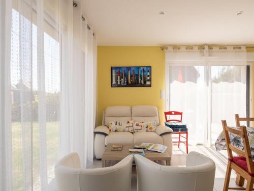 a living room with a couch and a table at Holiday Home Tal ar Mor by Interhome in Plouescat