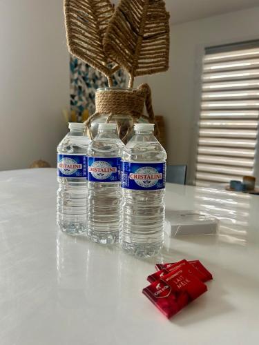 three bottles of water sitting on top of a table at Le Chez-Soi Lillois in Lille