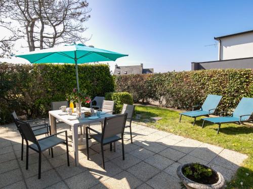 une table et des chaises avec un parasol sur une terrasse dans l'établissement Holiday Home An Theven by Interhome, à Cléder