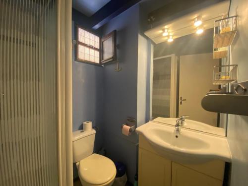 une salle de bain avec des toilettes blanches et un lavabo dans l'établissement Villa patio proche du port, à Capbreton
