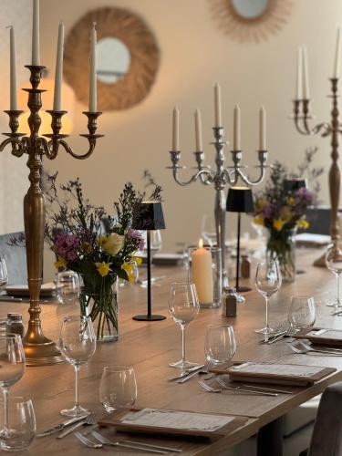 - une longue table avec des bougies et des verres à vin dans l'établissement Hôtel du Commerce-restaurant au Couteau, à Nogent