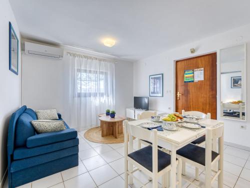 - un salon avec une table et une chaise bleue dans l'établissement Apartment Jurkovic-2 by Interhome, à Njivice
