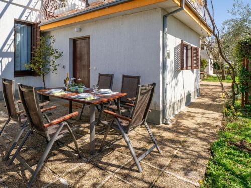 une table et des chaises devant une maison dans l'établissement Apartment Jurkovic-2 by Interhome, à Njivice