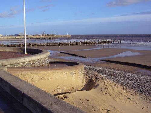 a sandy beach with a pier and the ocean at Kingsleigh Guest House in Lowestoft