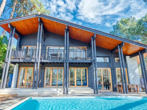 une maison avec une terrasse au-dessus d'une piscine dans l'établissement Villa Villa La Lisière des Pins by Interhome, à Lacanau-Océan