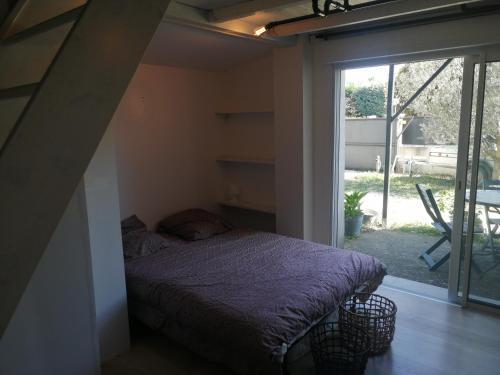 a bedroom with a bed and a large window at chalet sous le chant du chêne in La Roque-dʼAnthéron