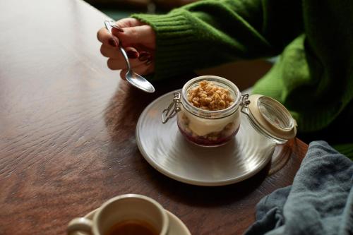 a person with a spoon and a jar of food at The George and Dragon - A Heartwood Inn in Marlow
