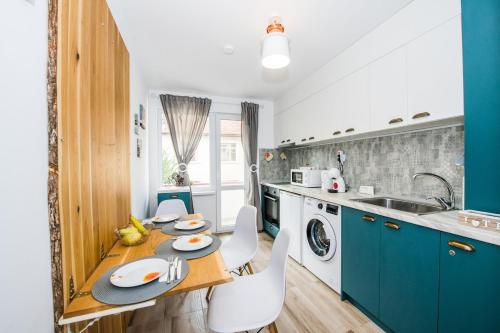una cucina con armadi blu, tavolo e sedie di Cozy 2BDRM near University & Free Street Parking a Veliko Tŭrnovo