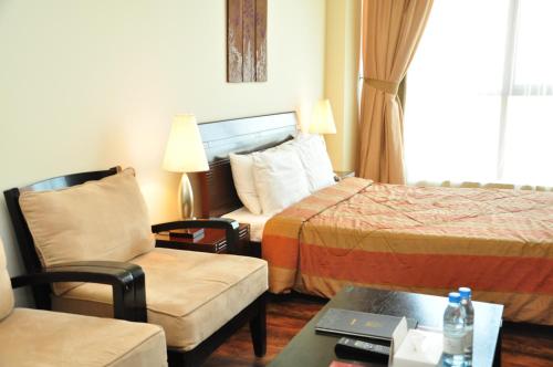 a hotel room with a bed and a chair at Al Manzil Hotel Bahrain in Juffair