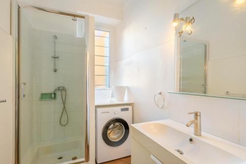 une salle de bain avec douche et machine à laver dans l'établissement Le Villeneuve Village, à Villeneuve-Loubet
