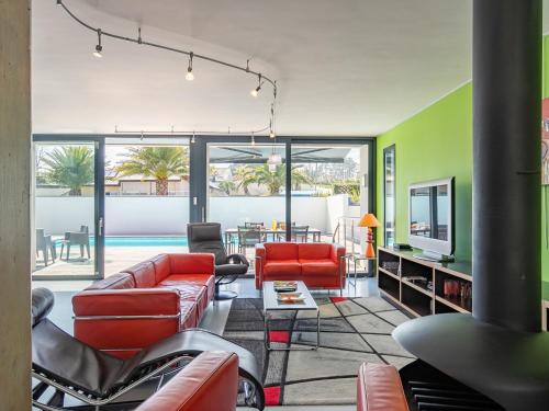 Il comprend un salon doté d'un mobilier rouge et d'une piscine. dans l'établissement Holiday Home Villa de la Baie by Interhome, à Locquirec
