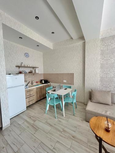 a kitchen and living room with a table and a couch at Shekvetili Seaside Apartment with Balcony in Shekvetili