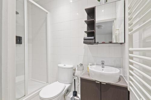 une salle de bain blanche avec des toilettes et un lavabo dans l'établissement Studio Appartement Quartier Tour Eiffel 10 Free Netflix, à Paris