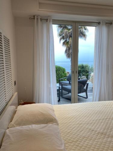 une chambre avec un lit et une vue sur l'océan dans l'établissement Vacances pieds dans l eau, à Casaglione