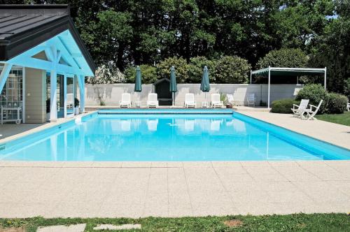 a swimming pool with chairs and a gazebo at Chalet La Forestière in Saint-Paul-en-Chablais