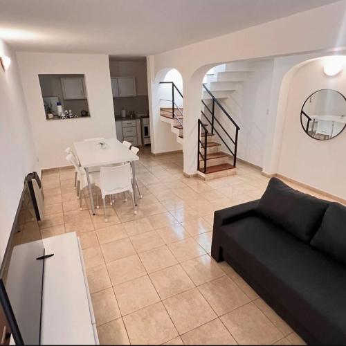 a living room with a black couch and a table at Dorrego Departamentos in Villa Dolores