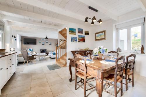 une cuisine et une salle à manger avec une table et des chaises dans l'établissement Maison pour 6 avec jardin, terrasse et jeux, à Saint-Frégant