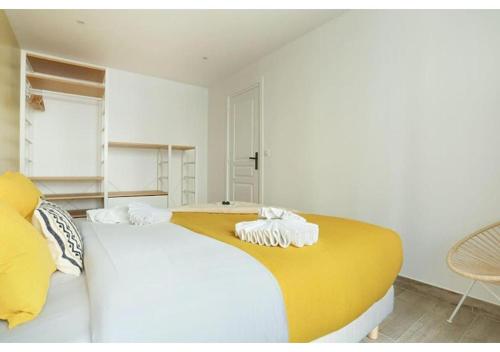 - une chambre avec un grand lit blanc et jaune dans l'établissement Apartment Center of Paris by Studio prestige, à Paris