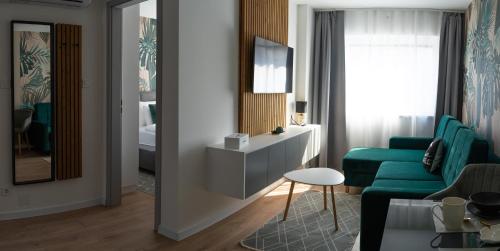 a living room with a green couch and a mirror at REMZ Apartments & Wellness in Dorog