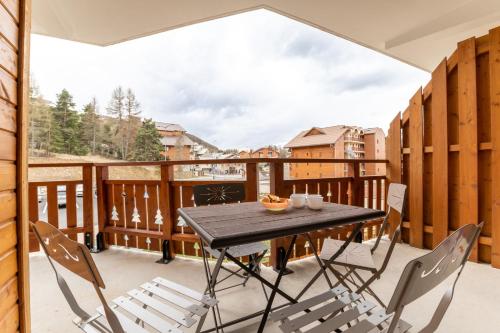 un patio avec une table et des chaises sur un balcon dans l'établissement Appartement pour 6 - 900m des pistes - terrasse, à La Joue du Loup