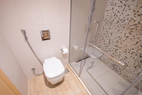 ein Badezimmer mit Toilette und Glasdusche in der Unterkunft Voyage Studio In Mayan With Partial Ocean Views in Abu Dhabi