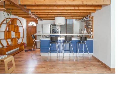 une cuisine avec un îlot bleu et des tabourets de bar dans l'établissement Maison Bordeaux Centre Petite Echoppe, à Bordeaux