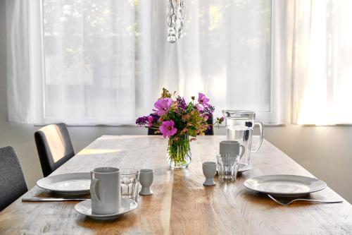 a wooden table with a vase of flowers on it at Gut Pälitzhof in Wustrow