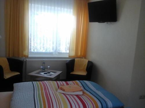 a bedroom with a bed and a table and a window at JaNettes Gästehaus in Bad Doberan