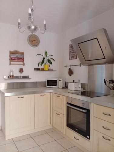 une cuisine avec des armoires blanches et un four à plaques de cuisson dans l'établissement T2 ajaccio ville, à Ajaccio