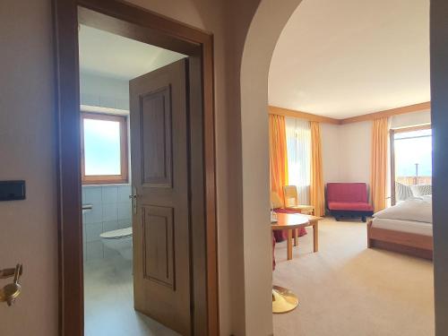 a bedroom with a bed and a room with a door at B&B Hotel Mair am Turm in Tirolo