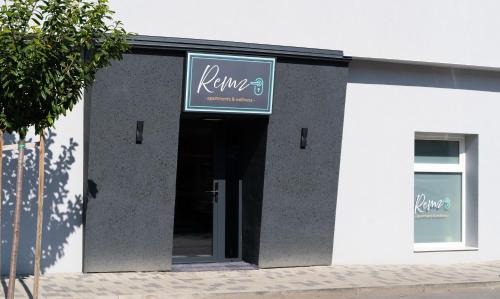 a sign on the side of a building with a door at REMZ Apartments & Wellness in Dorog
