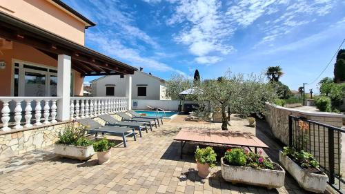 a patio with benches and a swimming pool at Apartments Kimm's Hideaway in Poreč