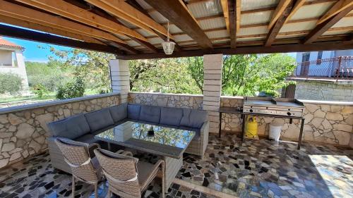 a patio with a table and a grill at Apartments Kimm's Hideaway in Poreč