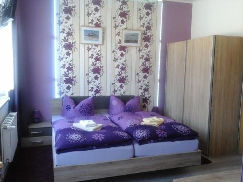 a purple bed with purple pillows in a bedroom at JaNettes Gästehaus in Bad Doberan