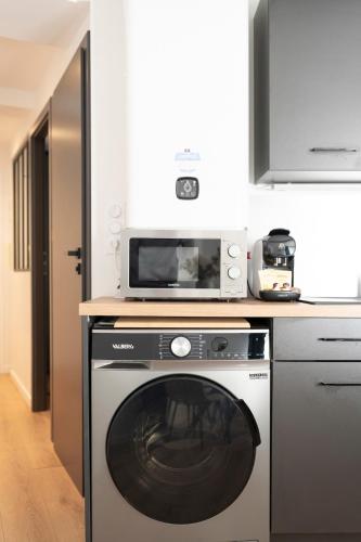 a kitchen with a washing machine and a microwave at Le Reflet de Gambetta - Place Stanislas - 2 pers - Nancy Centre in Nancy