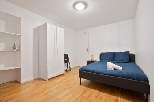 une chambre avec un lit bleu dans une pièce blanche dans l'établissement Heart of Paris - 2BR - 6P - Le Marais 8 Free Netflix, à Paris