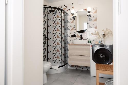 a bathroom with a sink and a washing machine at Apartament Szczerbowskiego A in Lublin
