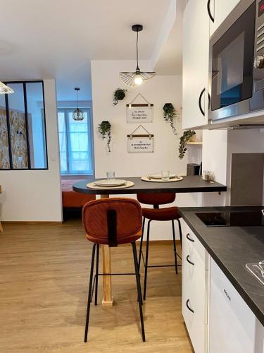 - une cuisine avec une table et deux chaises dans une pièce dans l'établissement Le Nid des Sœurs Macarons, à Nancy