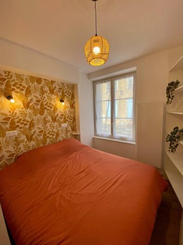 - une chambre avec un lit orange et une fenêtre dans l'établissement Le Nid des Sœurs Macarons, à Nancy