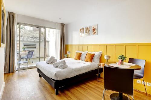 une chambre avec un lit, un bureau et une table dans l'établissement Eiffel residence Joséphine, à Paris