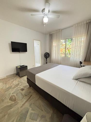 a bedroom with a large bed and a flat screen tv at Babilla Suites in Cali