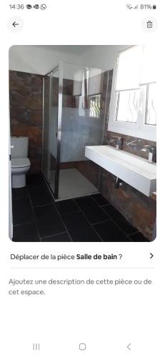 une salle de bain avec un lavabo, des toilettes et un miroir dans l'établissement Maison lumineuse et au calme, à La Celle-sous-Gouzon