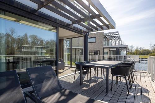 アルネマイデンにあるHello Zeeland - Veerse Wende - Lamsoor 9のデッキにテーブルと椅子が置かれたパティオ